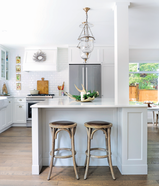 This white kitchen is the perfect backdrop for French Christmas décor. Here, miniature trees in stoneware crocks and a couple wreaths add holiday flair to the space.