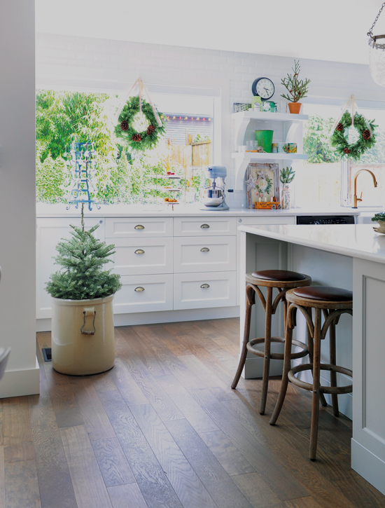 Various pieces of greenery are added to this white kitchen to complement the light foundation and give it a little bit of color. // Cottages & Bungalows