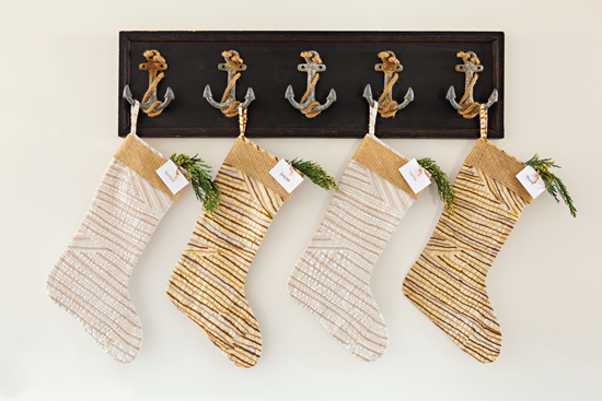 Instead of hanging above the fireplace, these stockings are hung beautifully from a piece of wall art with anchor hooks.
