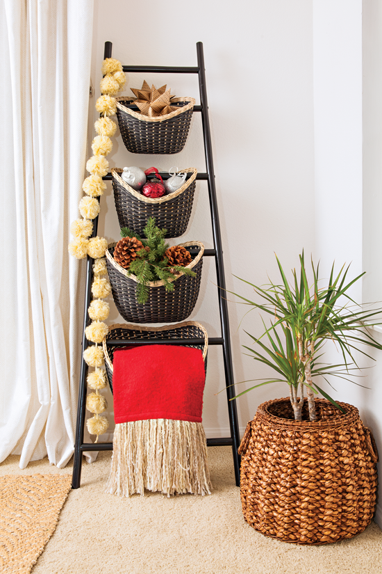 With a dash of creativity, a small black ladder is used as a place to spotlight baskets, a throw, decorations and a garland.