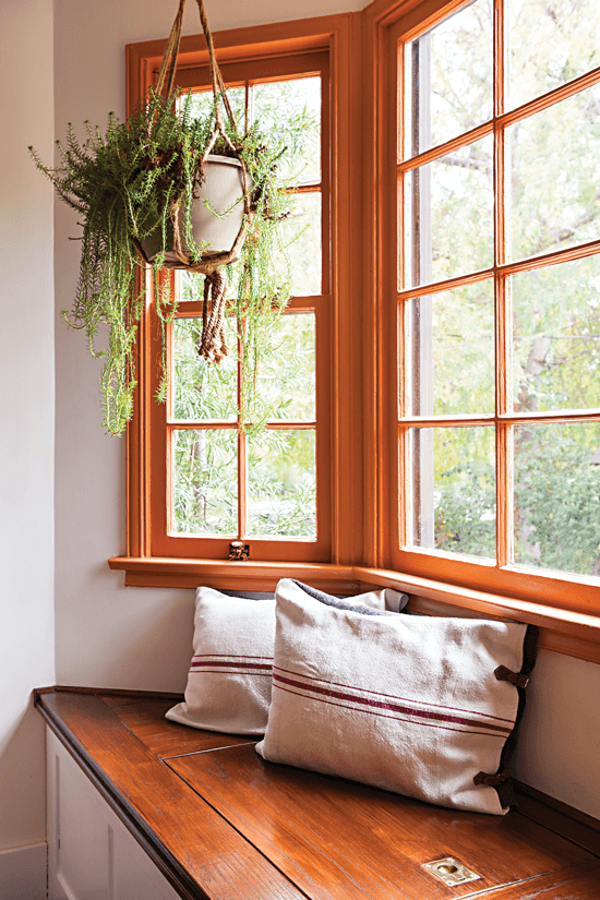 Handcrafted oak window seat and storage bench combo, styled with throw pillows made from Hungarian grain sacks.