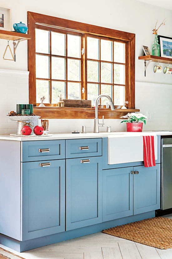 The large window over the kitchen sinks lets in a lot of natural light and enhances the beauty of the blue lower cabinets. 