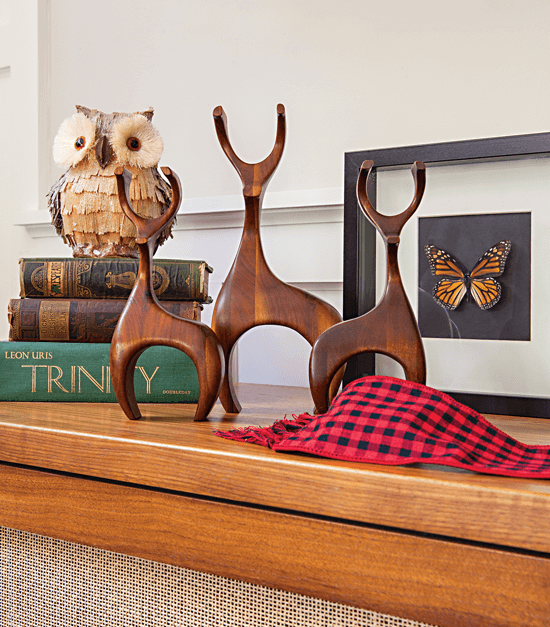 Wooden deer figures sitting on the media cabinet in the living room just below the television.