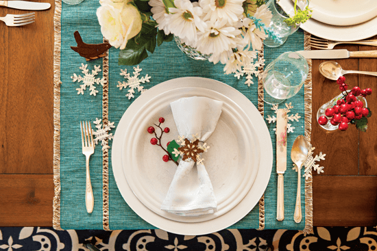 Snowflakes cut from old sheet music add a delightful layer of texture to the table.