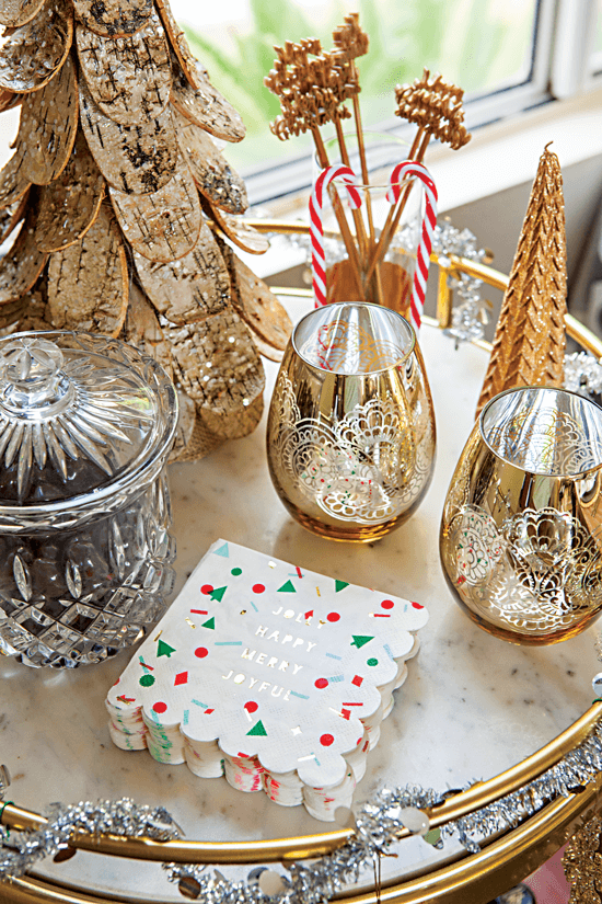 This holiday-inspired drink and snack cart is decorated with gold wine glasses with pops of red and green. // Cottages & Bungalows