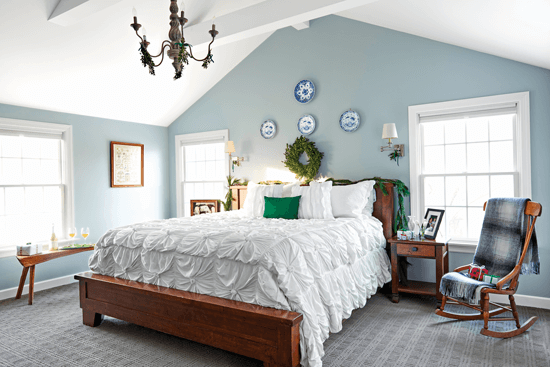 Light blue master bedroom accented with pops of fresh greenery and rustic boxwood.