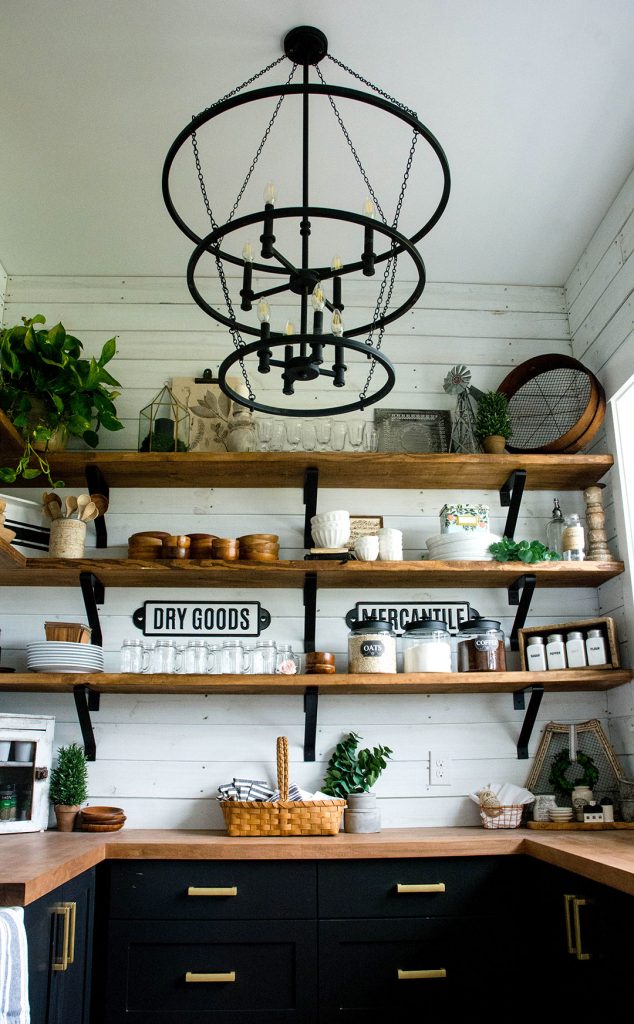 Farmhouse pantry with open shelves, black cabinetry and butcher block counters.