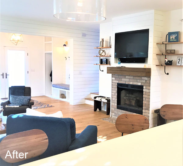 Fireplace with brick facade and reclaimed mantel in the Victory Farms home living room.