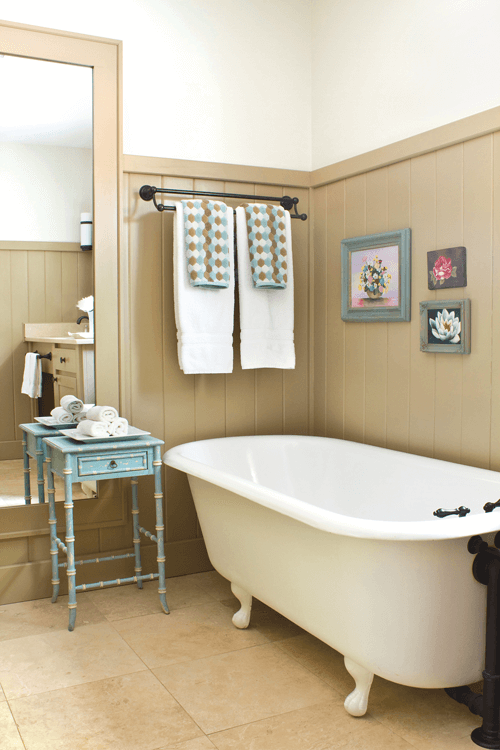 earthy neutrals were used in the bathroom for their spa-like shade, which helps the gorgeous white clawfoot tub pop against the wainscoting