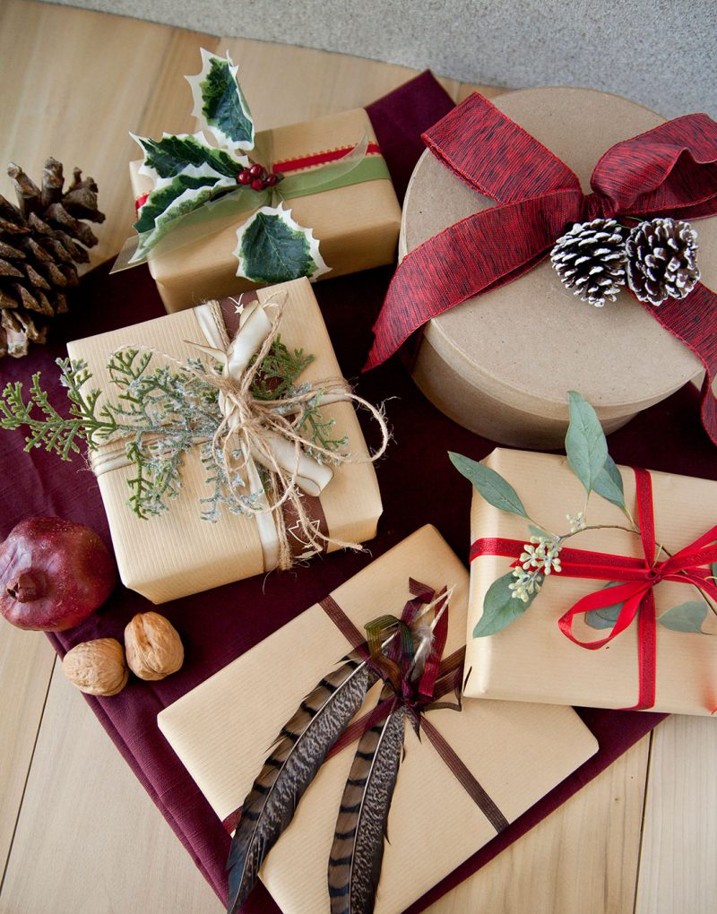 Christmas presents wrapped in brown wrapping paper with natural embellishments.