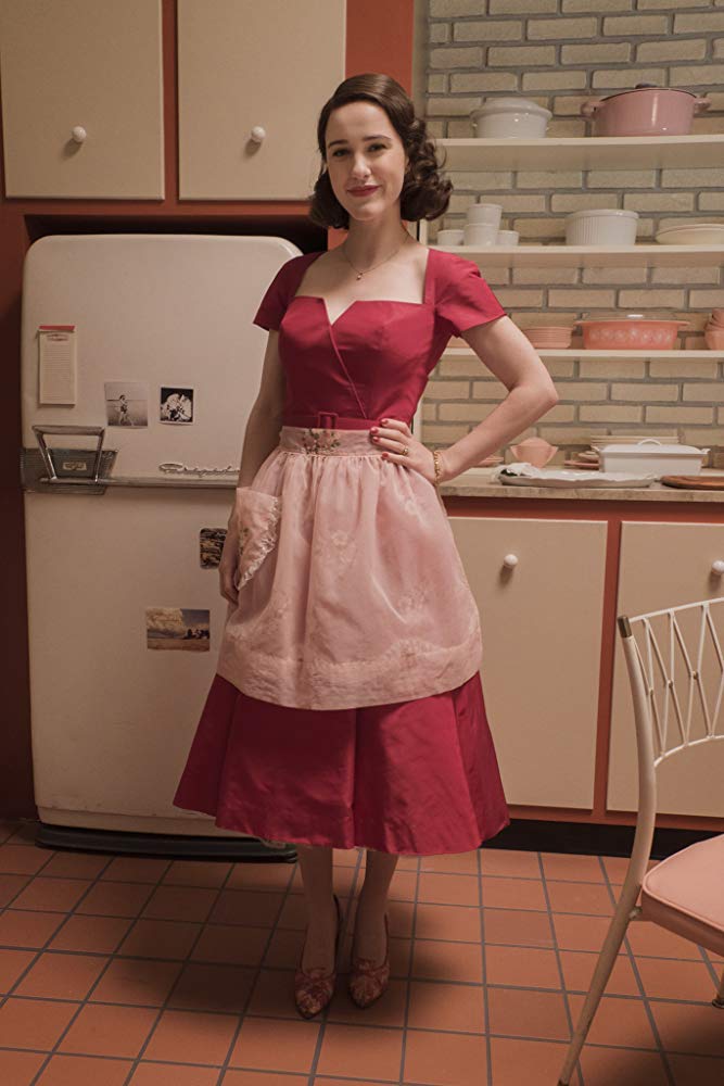 Midge Maisel played by the charming Rachel Brosnahan standing in her 1950s-inspired kitchen.