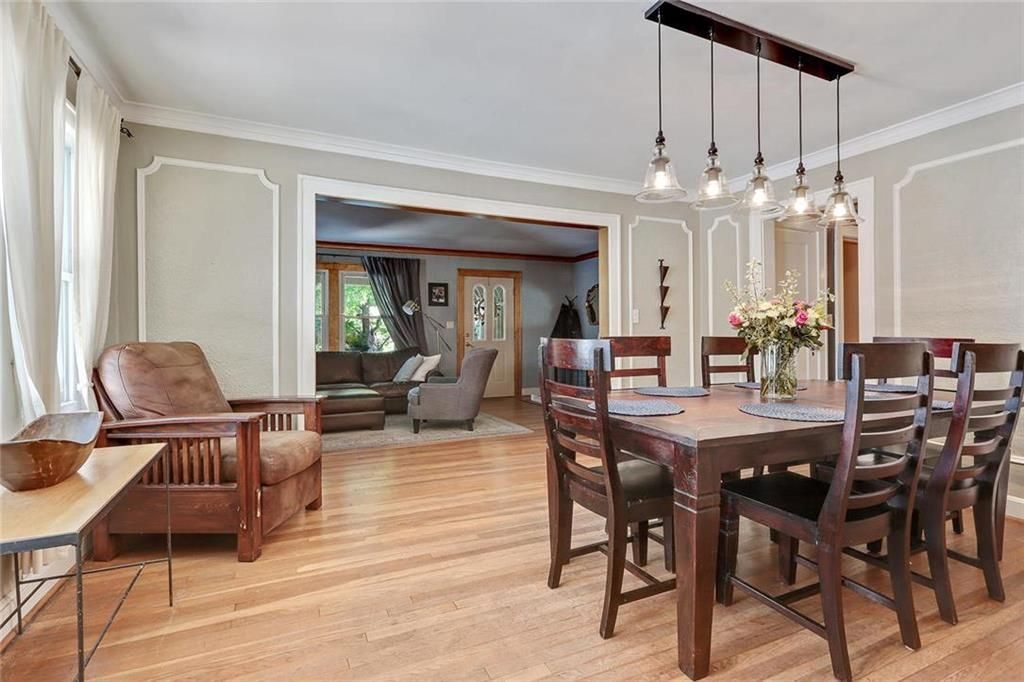 Cottage dining room with wainscoting and an industrial light fixture.