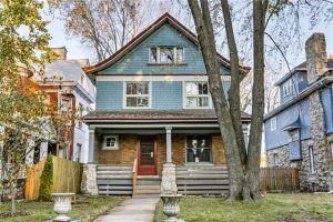 blue cottage with brick and siding.