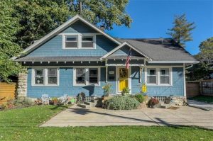 Great blue cottage with a yellow door for sale in Kansas City!