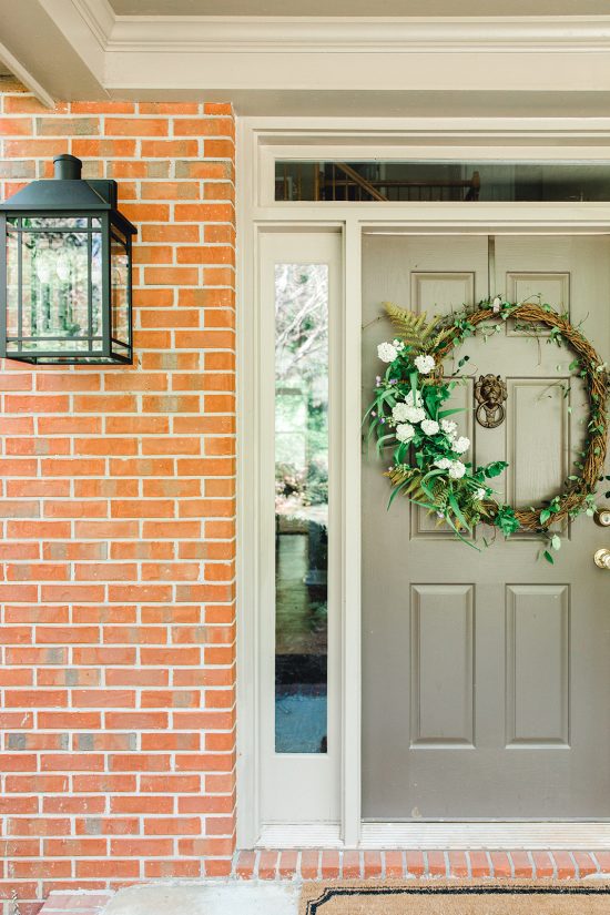 Front door close-up featuring a simple wreath and lantern from Capital Lighting's Braden Collection.