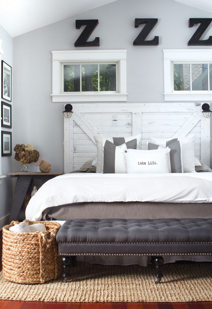 Charming lake cottage bedroom with reclaimed wood headboard and clutter free design