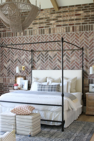 Master bedroom decorated with French country décor and a herringbone brick accent wall, featuring a beautifully beaded chandelier from Capital Lighting's Kayla Collection.