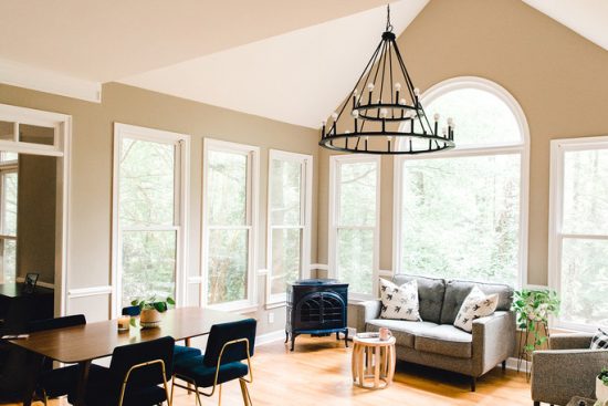 The sitting area in this kitchen boasts high ceilings and large windows, making it the perfect place for this 24-light chandelier from Capital Lighting's Pearson Collection.