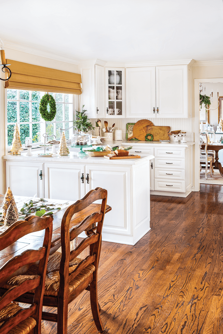 White cabinetry, rich wood tones and antique accessories create a calm, clean and character-filled atmosphere in the Maison de Cinq kitchen.