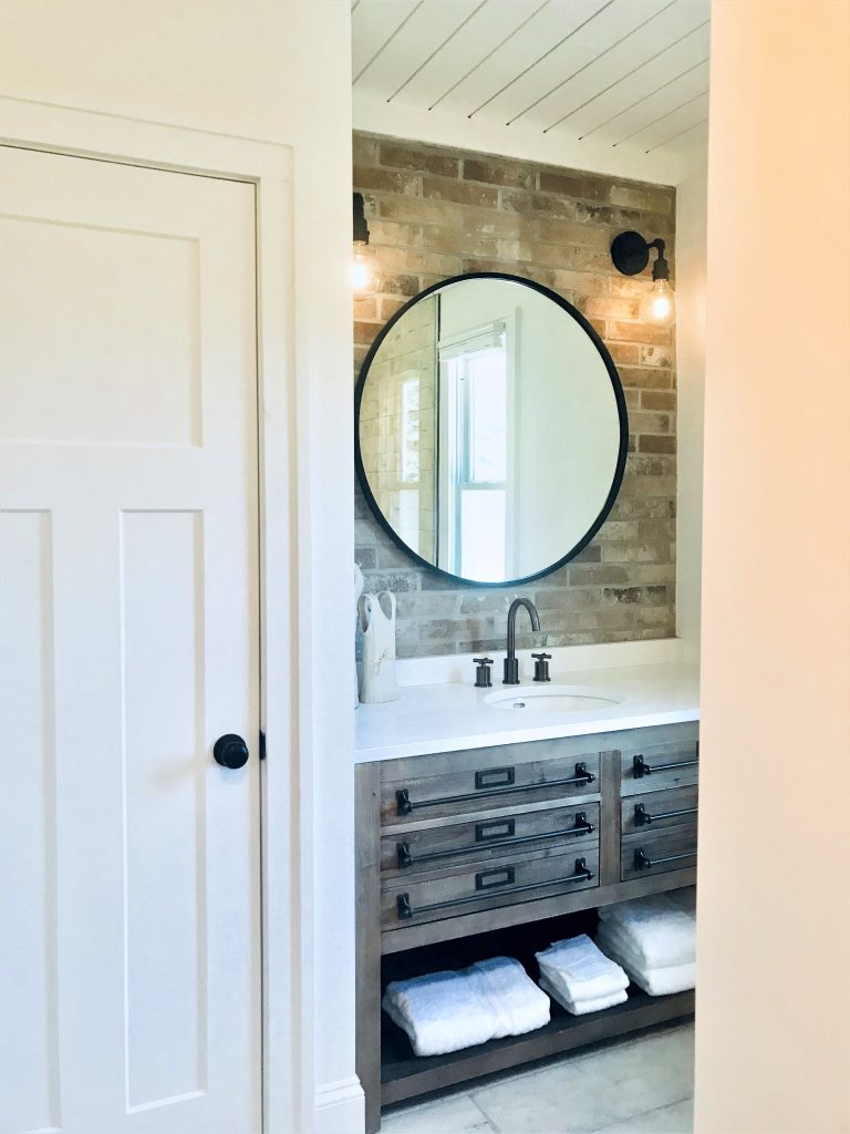 Bathroom remodel using brick and a reclaimed wood vanity. 