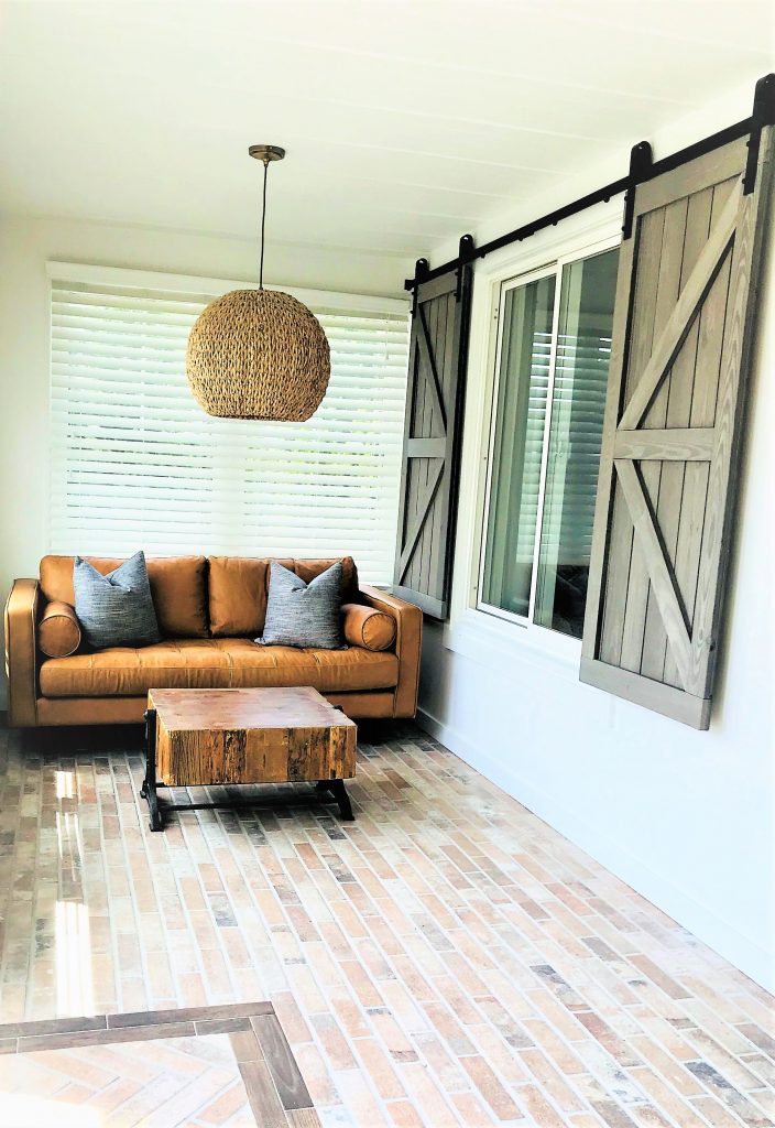 Remodeled bungalow sunroom with brick-like tile flooring. 