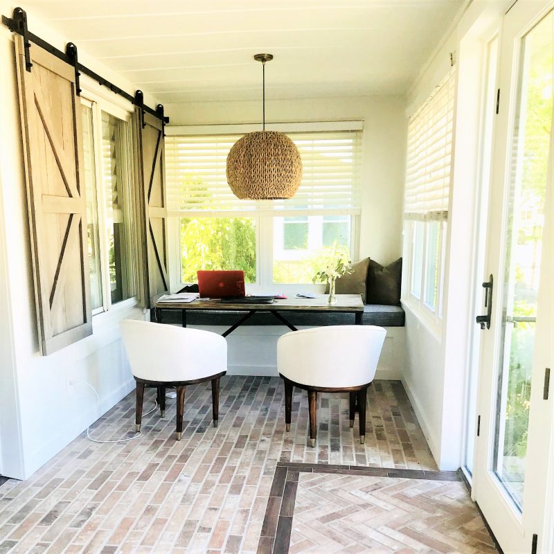 Remodeled sunroom with brick-look tile flooring and a simple but efficient and stylish office nook.