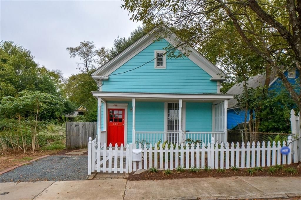 Colorful quaint cottage in Atlanta with white picket fence. 