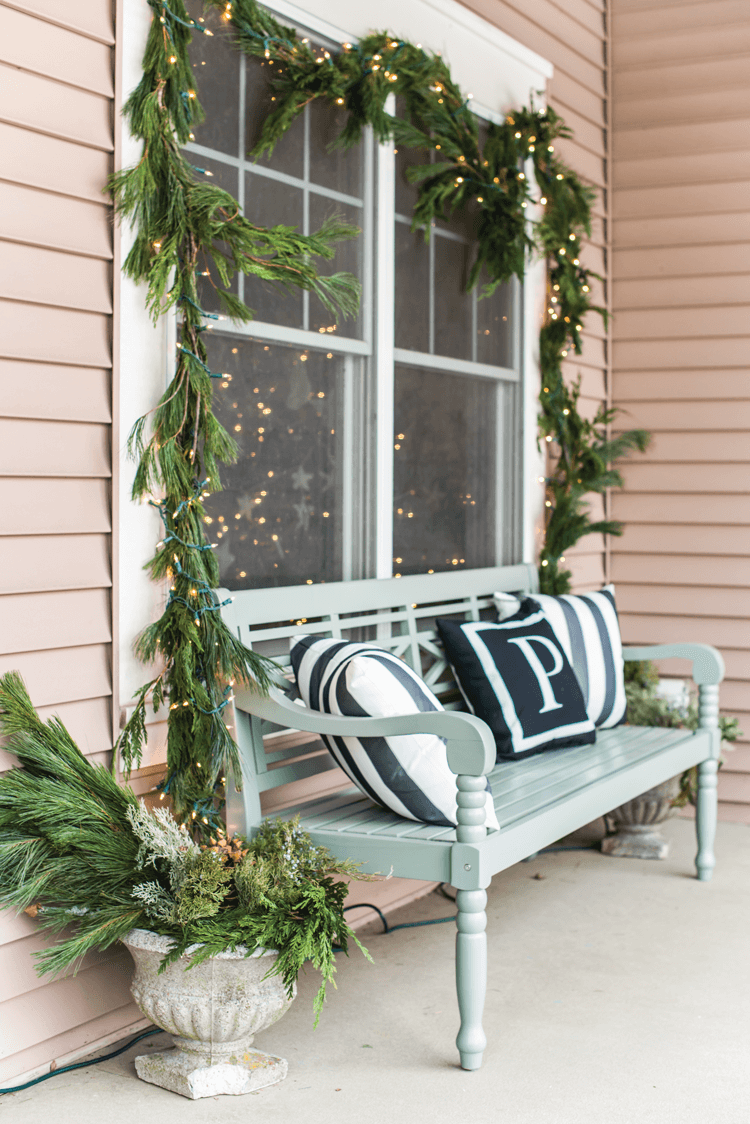 A blue painted bench creates a welcoming winter scene on Marian Parson's front porch. Fresh greenery strung with lights completes the look.