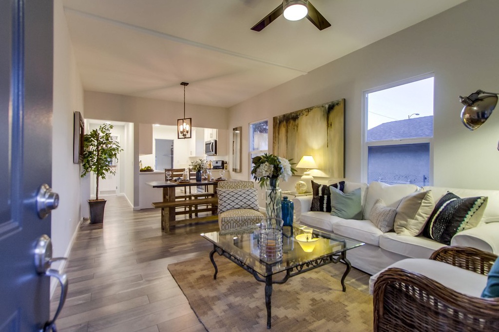 Living room of a San Diego cottage furnished with sofa, coffee table, chairs, and rug.