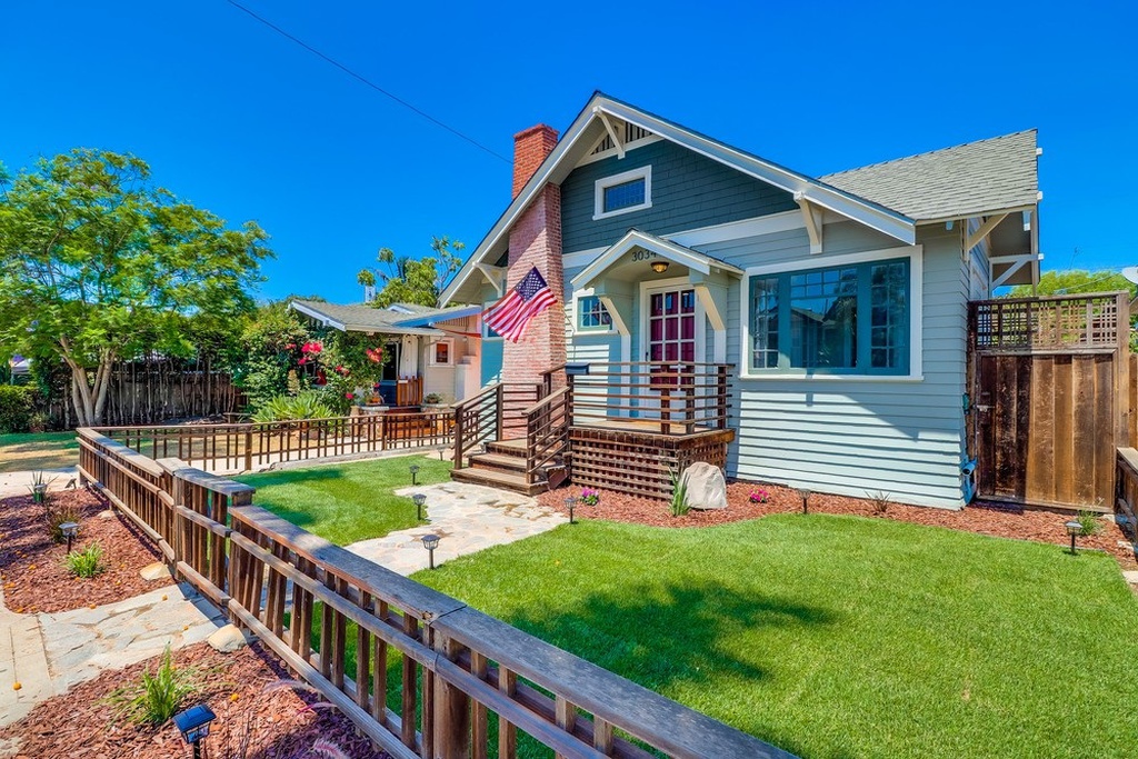 light blue historic cottage with front yard fence