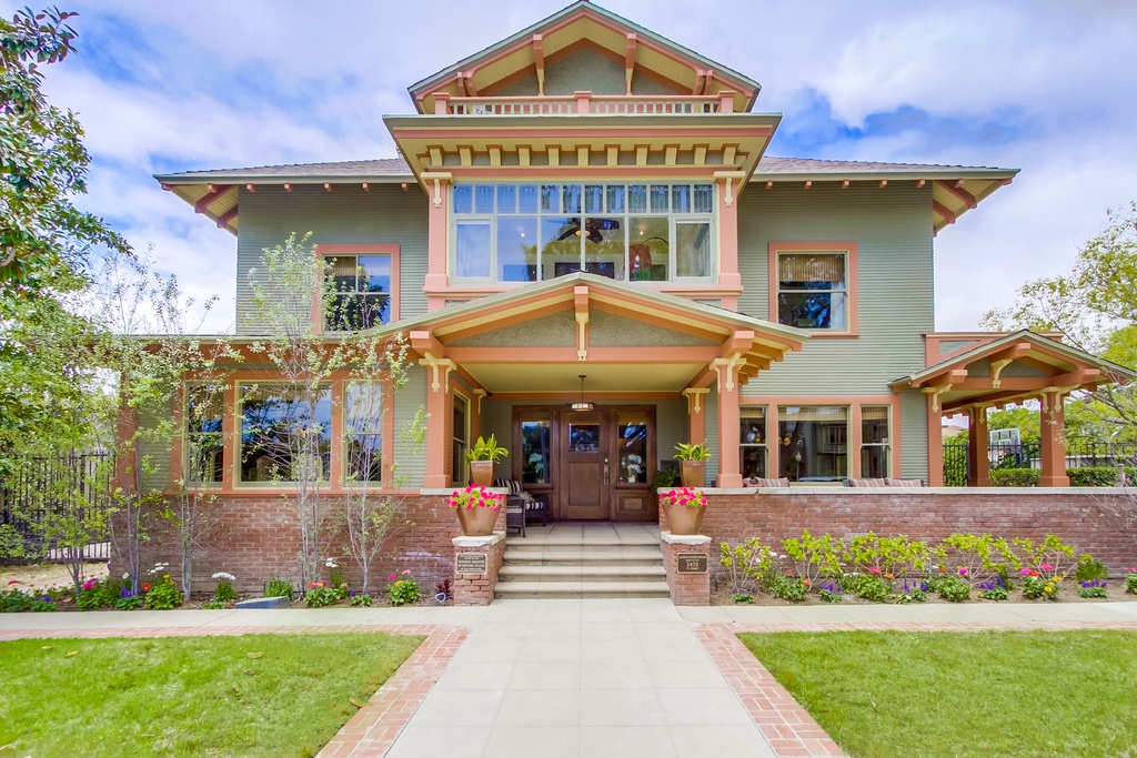 The exterior of a historic San Diego home painted a pastel green and orange.