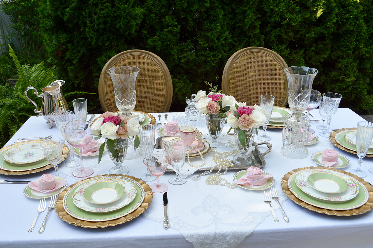 romantic table setting with gold cane chairs, roses and limoge china