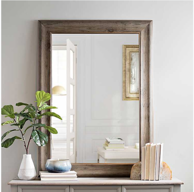 A mirror with a wood and bronze frame.