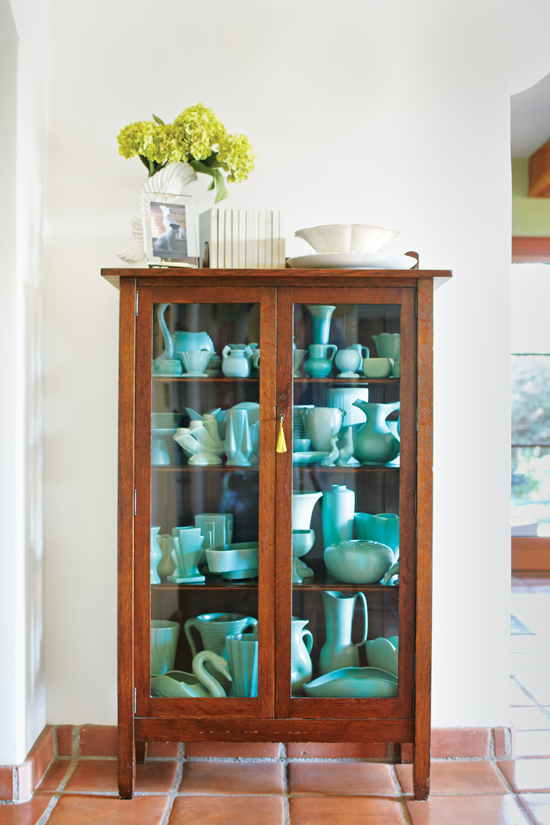 glass cabinet with blue california pottery