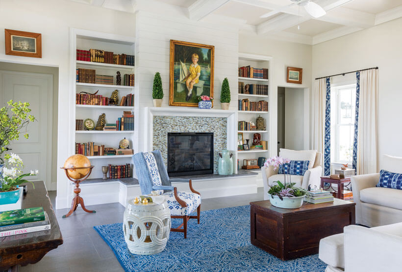 Cool shades of blue and white counter the warmer tones of dark wood finishes and antique books