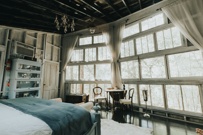 A wall of windows allows for stunning views of the wooded surroundings and plenty of natural light. The treehouse's height ensures privacy.
