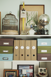 Open shelves with shoeboxes and magazine holders. A vintage birdcage and other accessories decorate the top shelf.