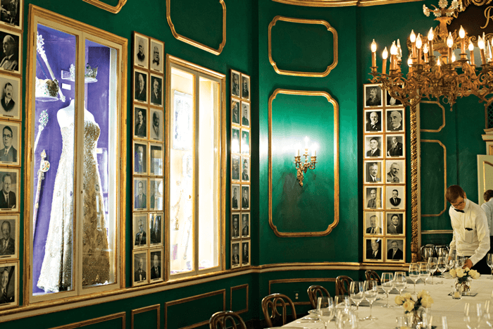 The Green Room at Antoine's Room lined with photographs of past Mardi Gras Queens.