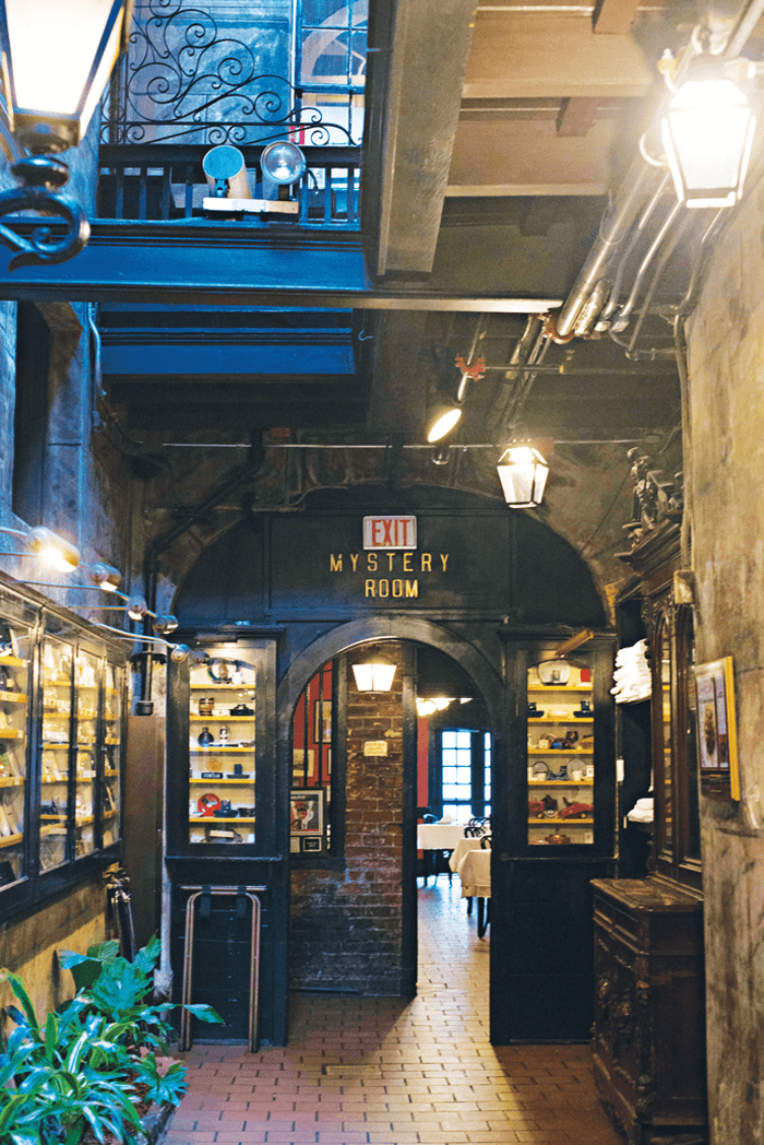 The entry to the Mystery Room accented by arched doorways and brick walls. 