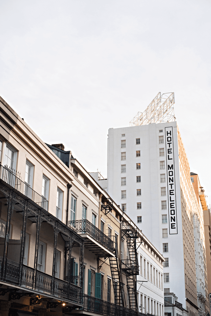 Street view up at the Hotel Monteleone and fire escapes and balconies of the building next to it. 