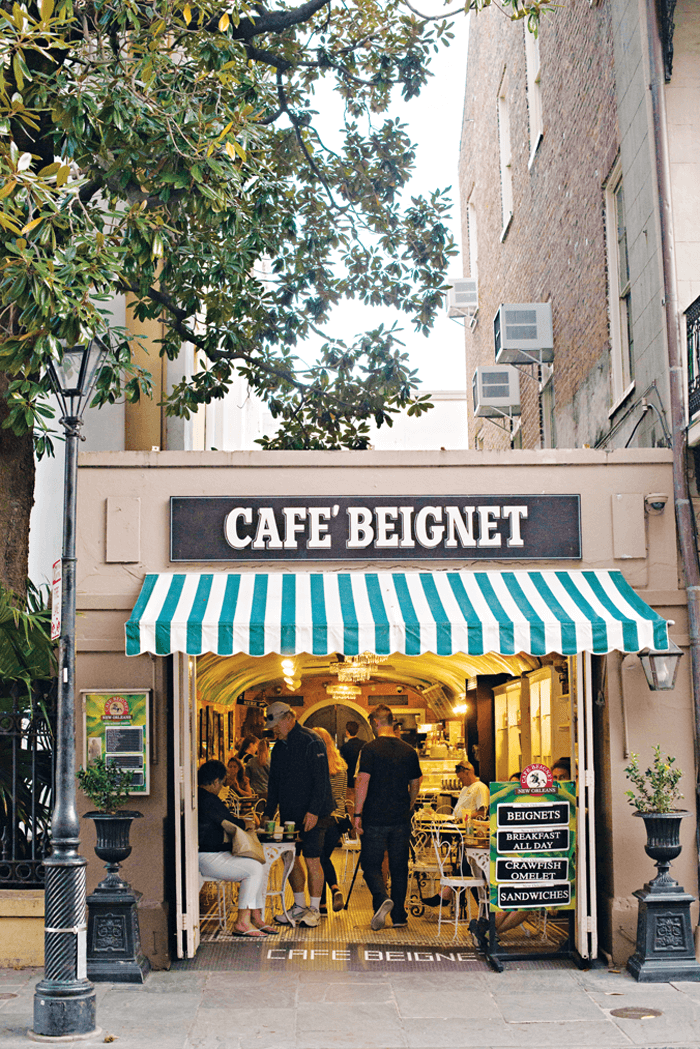 New Orleans store front of Cafe Beignet filled inside with eating patrons. 