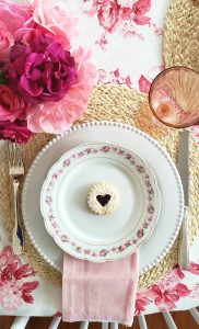 heart cookie on a chintz plate for a pink and red galentines tablescape