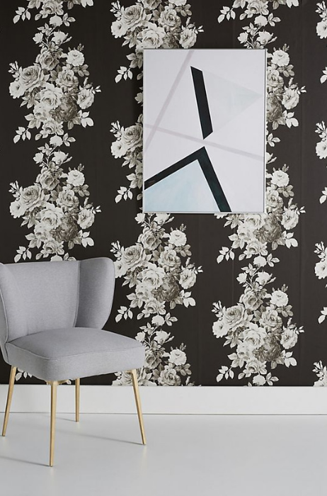 Bold black and gray floral wallpaper , framed wall artwork and a gray armchair