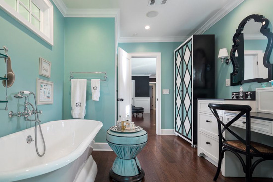 Blue bathroom with black and white accented tub and vanity. 