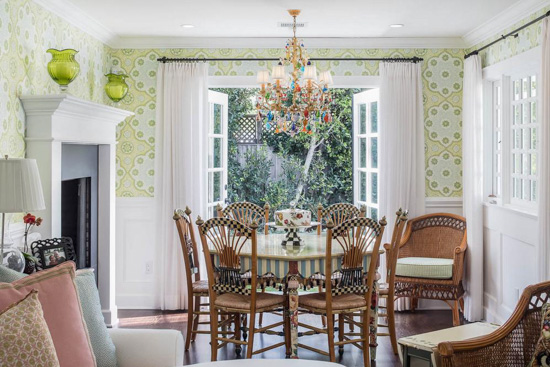 Cottage style dining room with table and chairs and French doors open to the backyard.