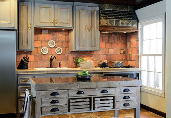 Old world kitchen with terra-cotta tile backsplash and antique island