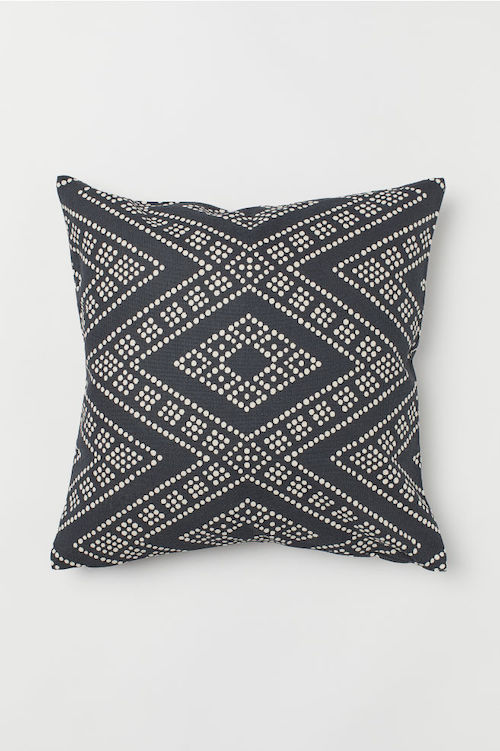 A black cushion cover with a white diamond pattern.