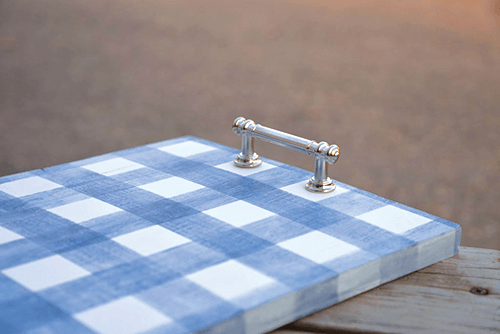 Finished tray with a blue gingham pattern and affixed silver handle to make it into a serving tray. 