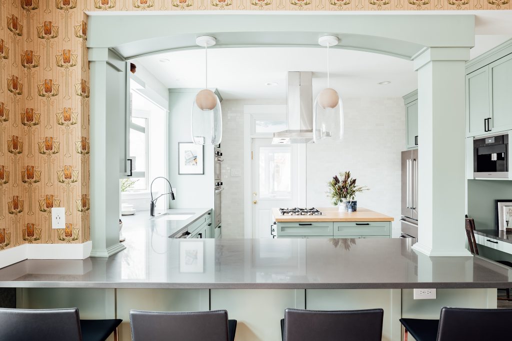 a blue archway frames a view into a remodeled kitchen. 