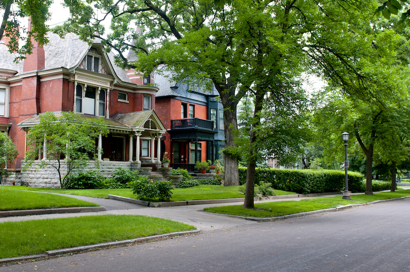 An older home on a tree-lined street.